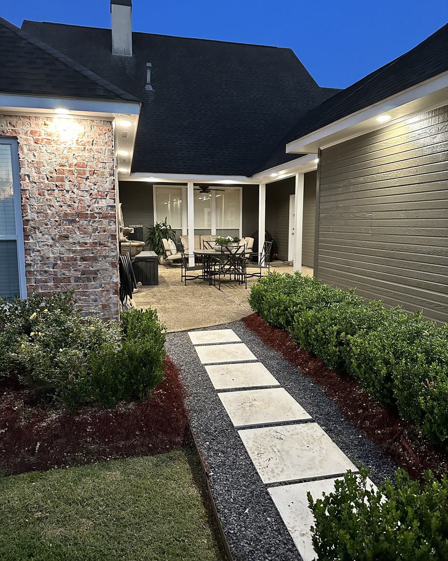 A garden walkway lit at night by low landscape lights