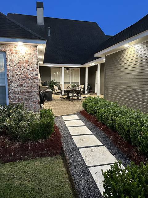 A garden walkway lit at night by low landscape lights