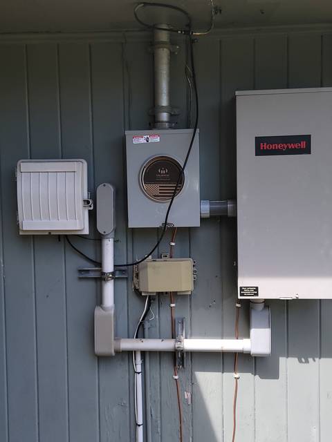 A meter, a panel and switch gear mounted on siding